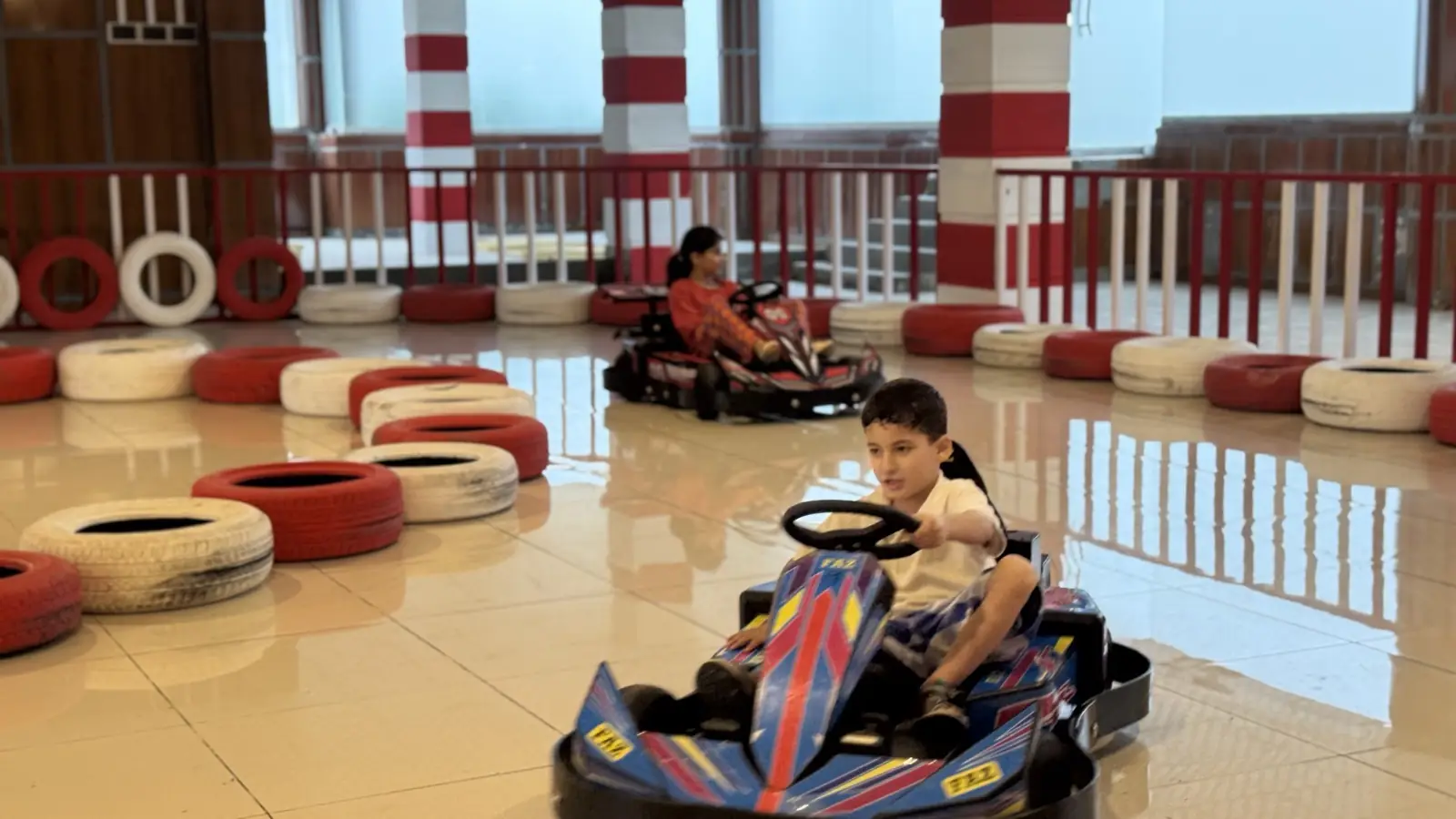 Child smiling while driving a go-kart at Funzania