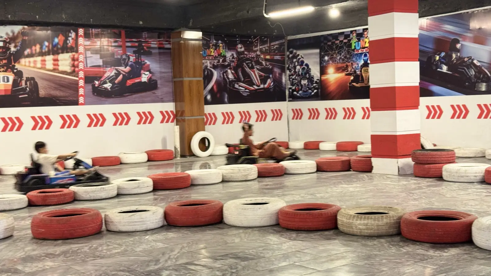 Two go-karts on the indoor track at Funzania
